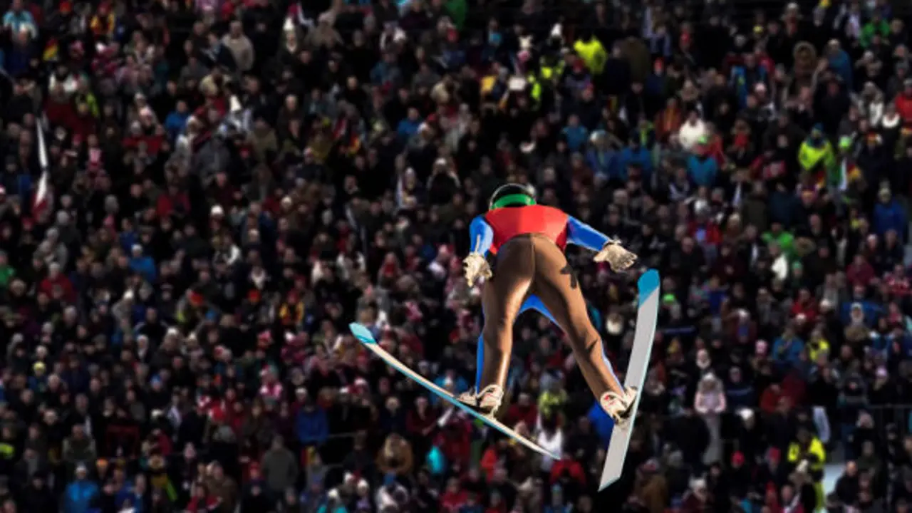 Young man jumping on the large hill, audience watching