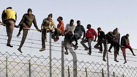 Inmigrantes asaltando la valla de Melilla (2014)