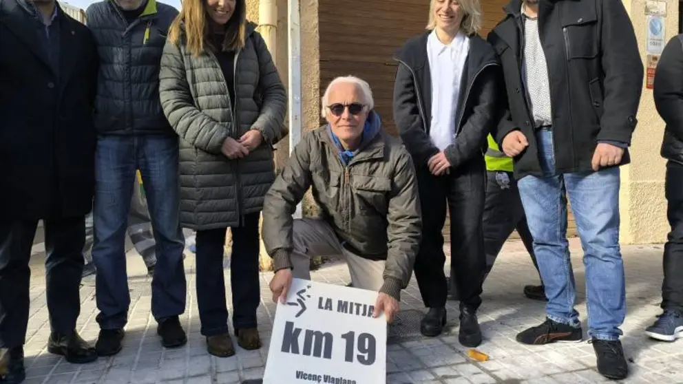 Vicen&ccedil; Viaplana col.locant la seva placa al km 19 de la Mitja